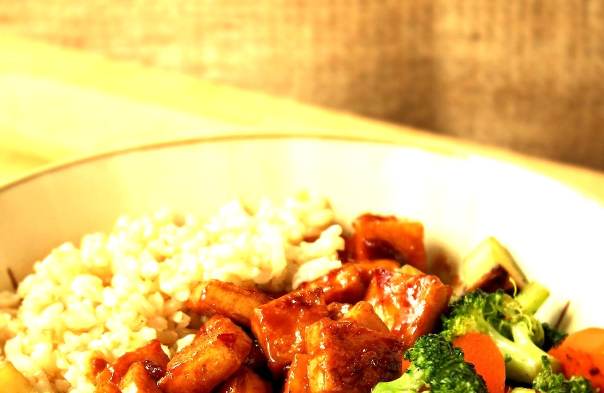 Stir-fried broccoli, carrots, and zucchini, brown rice, and teriyaki peanut tofu.